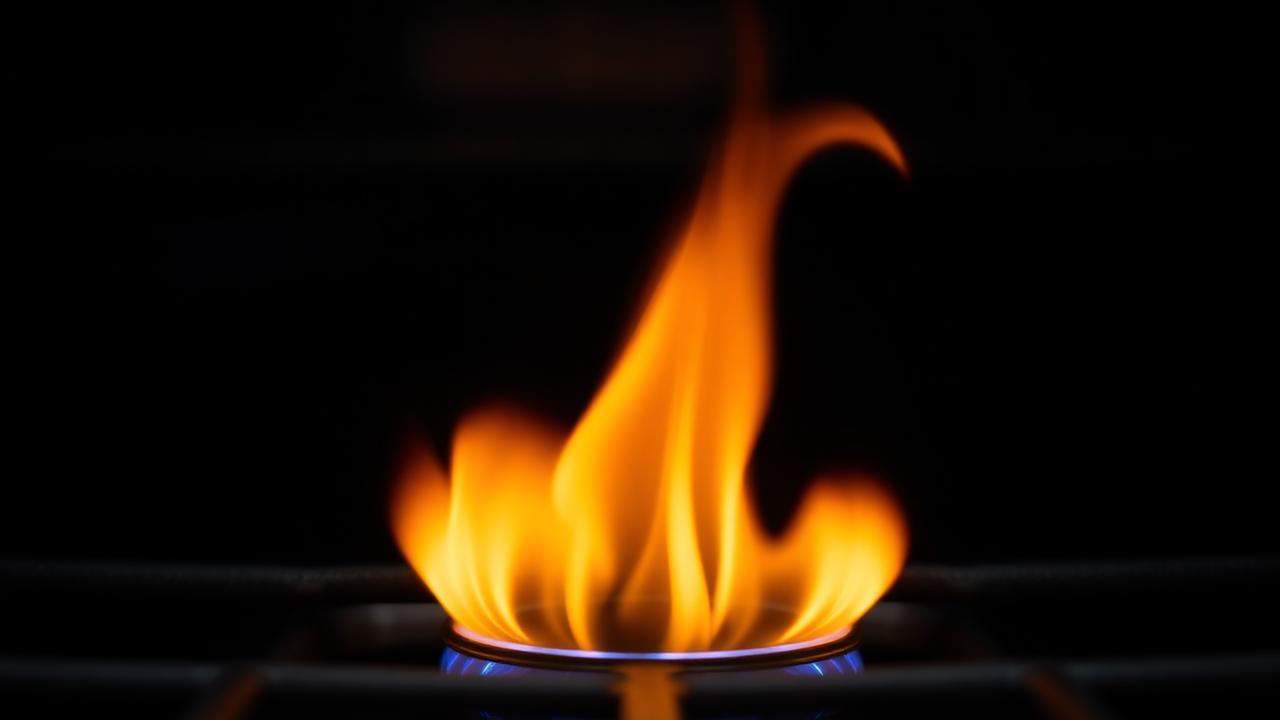 Gas grill burner with oversized flame indicating excess pressure